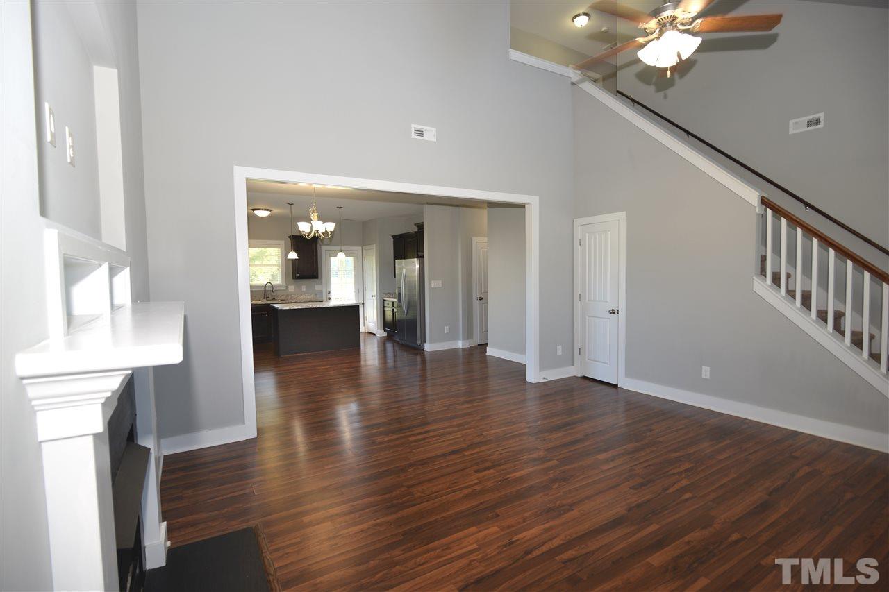 179 Red Wood Road Zebulon, NC 27597 - Photo 6 of 25 a view of a hallway with wooden floor and a chandelier