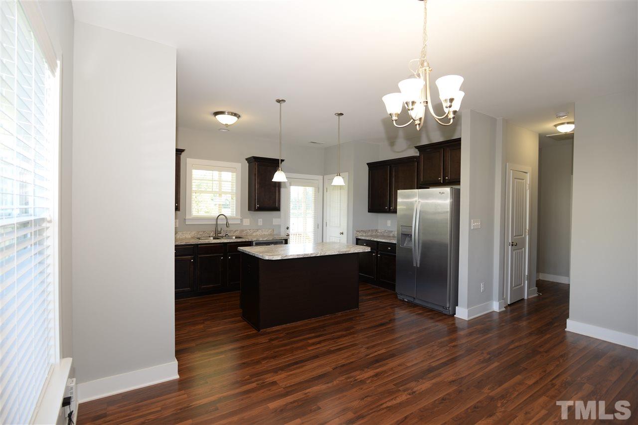 179 Red Wood Road Zebulon, NC 27597 - Photo 7 of 25 a large kitchen with a wooden floor and refrigerator