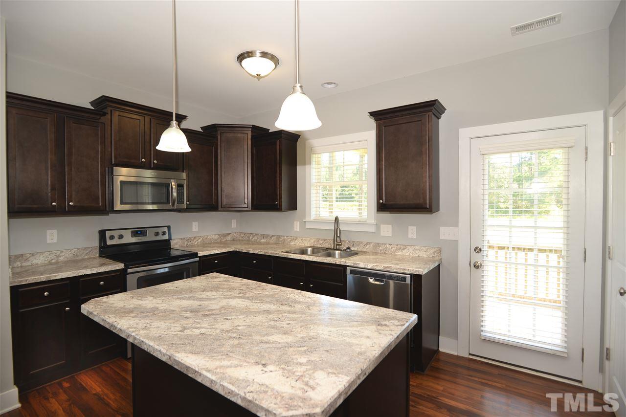 179 Red Wood Road Zebulon, NC 27597 - Photo 8 of 25 a kitchen with a sink a center island and cabinets