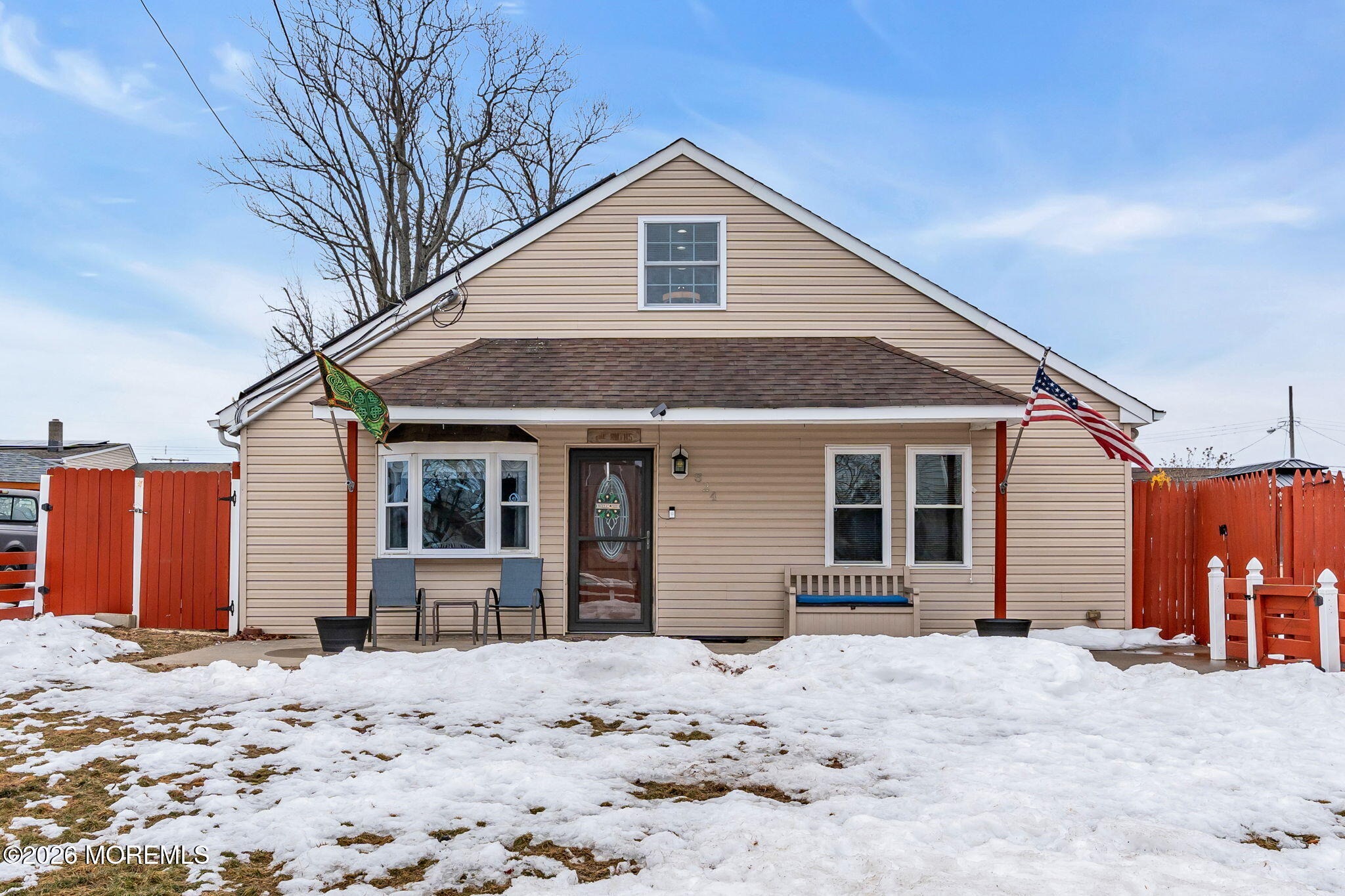 a front view of a house with a yard covered in snow