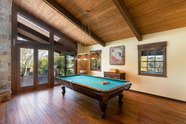 a room with pool table and windows