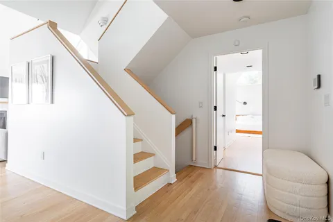 a view of a hallway with wooden floor and staircase