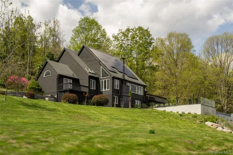 a view of a house with a big yard and large trees