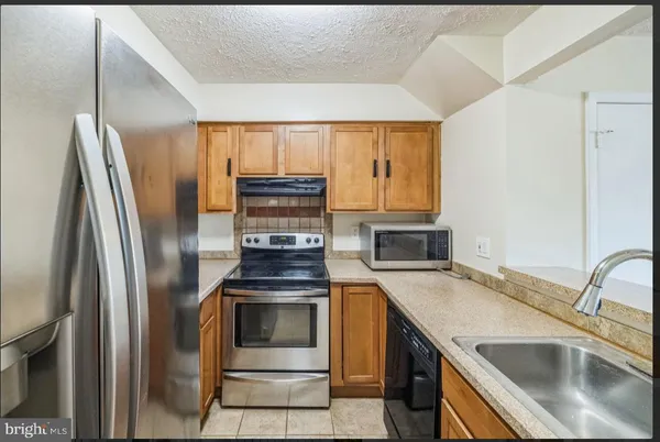 a kitchen with a sink stove and refrigerator