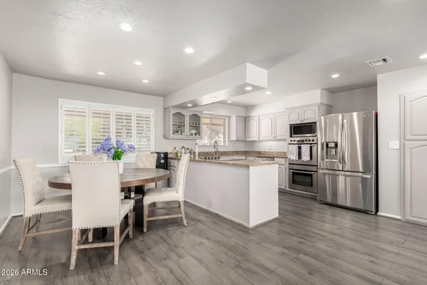 a kitchen with white cabinets and stainless steel appliances