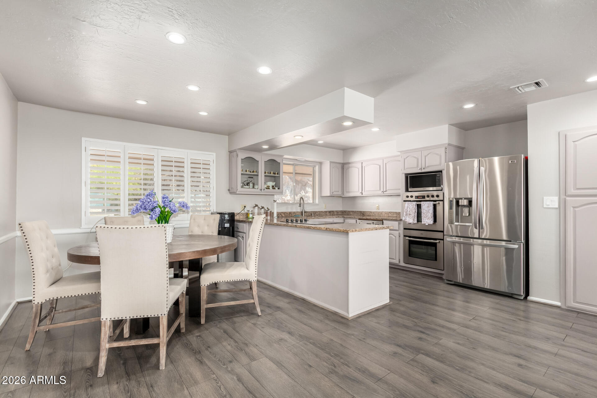 6526 North 37th Street Phoenix, AZ 85018 - Photo 16 of 51 a kitchen with white cabinets and stainless steel appliances