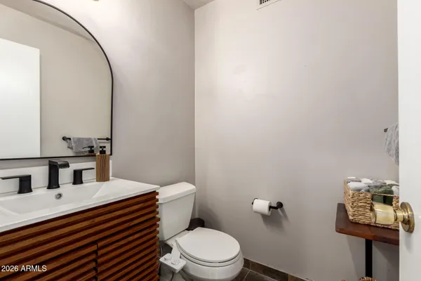 a bathroom with a sink a toilet and mirror