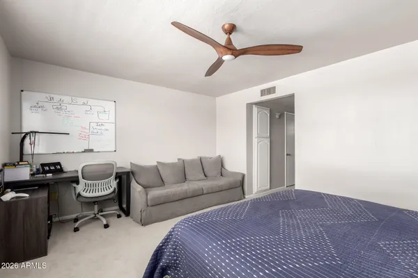 a bedroom with bed cabinet and window