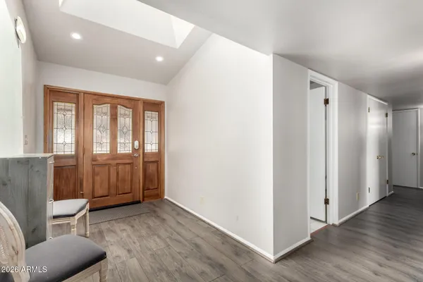a view of a hallway with furniture and wooden floor