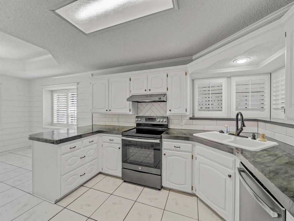 121 Northeast Brushy Mound Road Burleson, TX 76028 - Photo 11 of 35 a kitchen with granite countertop white cabinets white appliances and sink