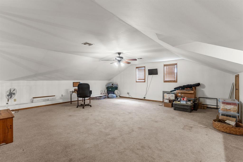 13315 Highway 281 Scotland, TX 76379 - Photo 29 of 40 Large loft featuring a sloped ceiling and multiple windows with wood blinds