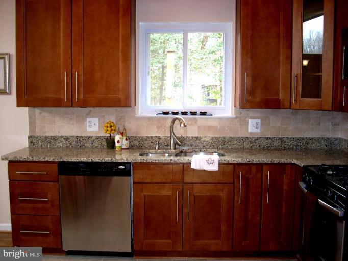 8715 Clydesdale Road Springfield, VA 22151 - Photo 11 of 19 a kitchen with granite countertop wooden cabinets a sink and a stove