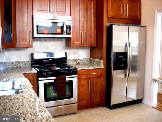 8715 Clydesdale Road Springfield, VA 22151 - Photo 4 of 19 a kitchen with stainless steel appliances granite countertop a stove a microwave and a refrigerator