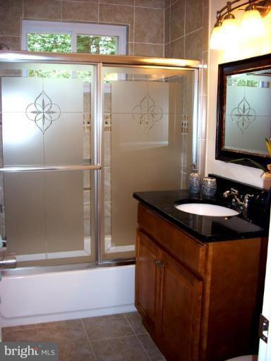 8715 Clydesdale Road Springfield, VA 22151 - Photo 6 of 19 a bathroom with a granite countertop sink a mirror and shower