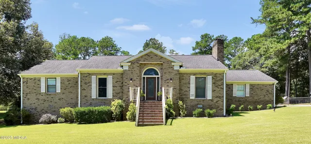 a front view of a house with a garden