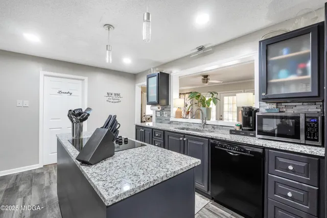a kitchen with stainless steel appliances granite countertop sink stove and refrigerator
