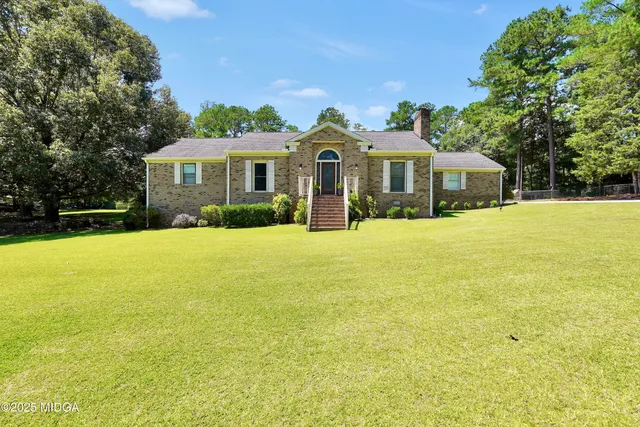 a front view of a house with yard and green space