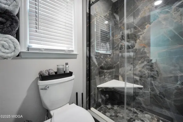 a bathroom with a toilet a sink and a window