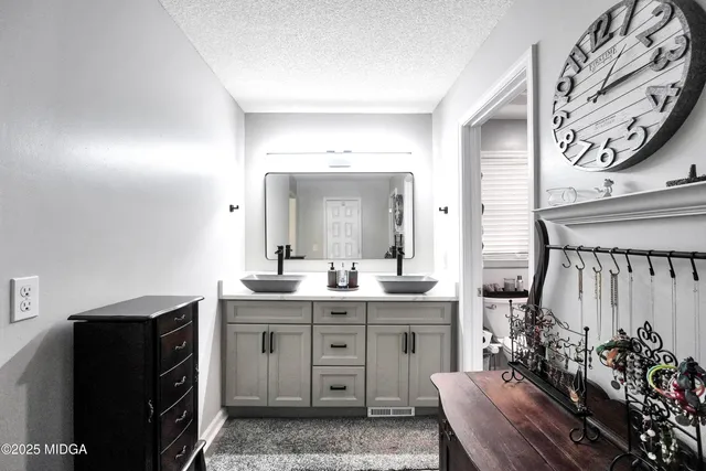 a spacious bathroom with a granite countertop sink a mirror and a toilet