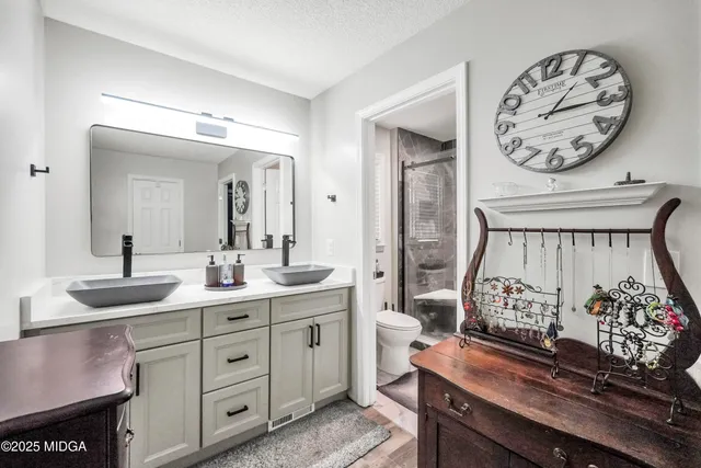 a en suite bathroom with a toilet a sink and mirror