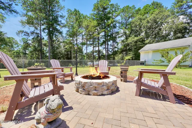 a view of a patio with a table and chairs potted plants with wooden floor and fence