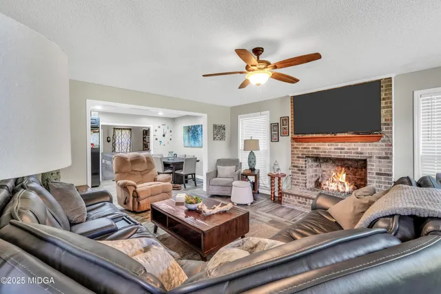 a living room with furniture a fireplace and a flat screen tv
