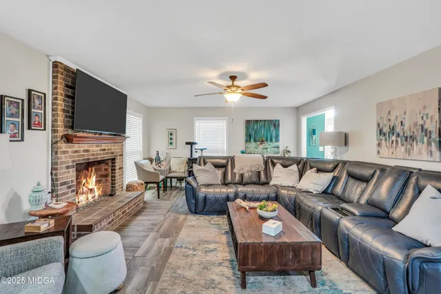 a living room with furniture a fireplace and a flat screen tv