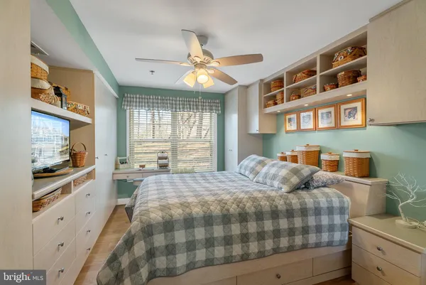 a bedroom with a bed and a flat tv screen on dresser