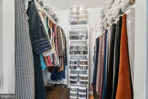 a view of walk in closet with clothes and shoes