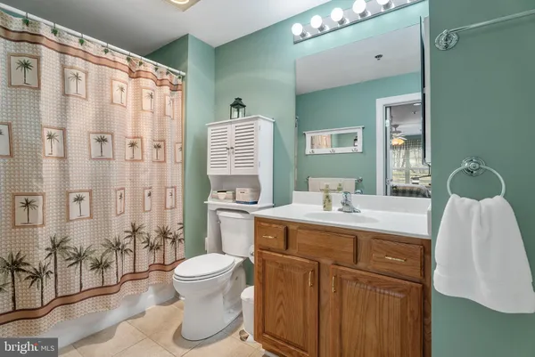 a bathroom with a granite countertop sink a toilet and shower