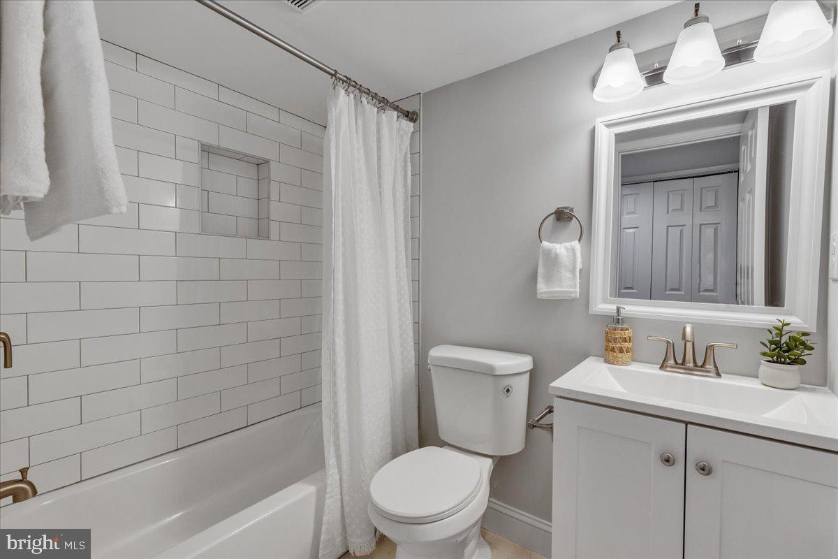 3908 Rokeby Road Baltimore, MD 21229 - Photo 24 of 28 a bathroom with a toilet a sink a mirror and shower