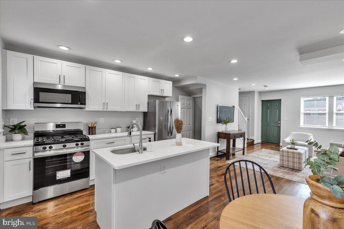 3908 Rokeby Road Baltimore, MD 21229 - Photo 9 of 28 a kitchen with a table chairs microwave and cabinets