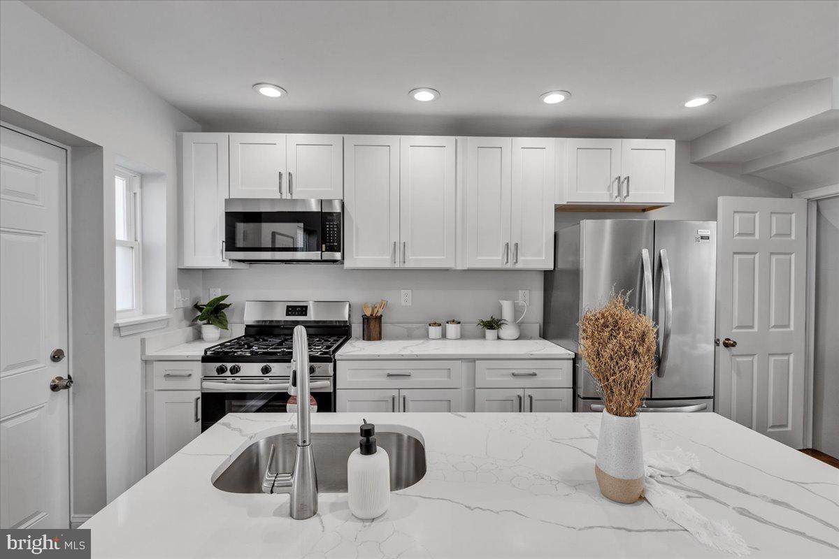 3908 Rokeby Road Baltimore, MD 21229 - Photo 10 of 28 a kitchen with a sink white cabinets and stainless steel appliances