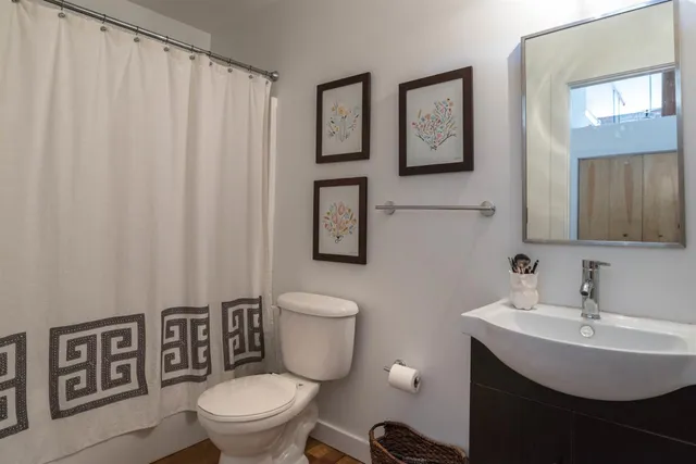 a bathroom with a toilet a sink and a mirror