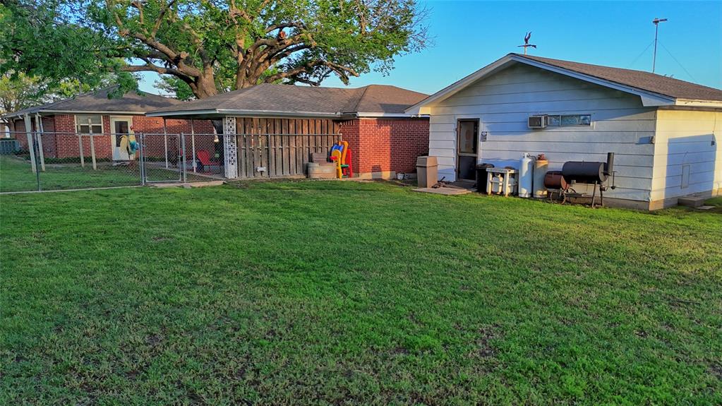 522 Montague Street Nocona, TX 76255 - Photo 20 of 25 a view of a yard in front of a house with large windows