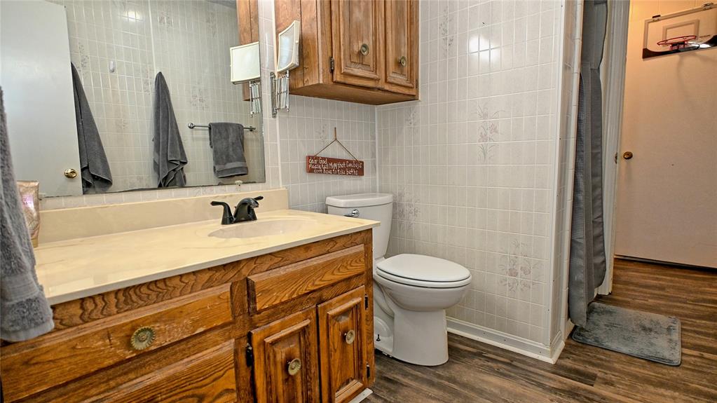 522 Montague Street Nocona, TX 76255 - Photo 9 of 25 a bathroom with a sink a toilet and mirror