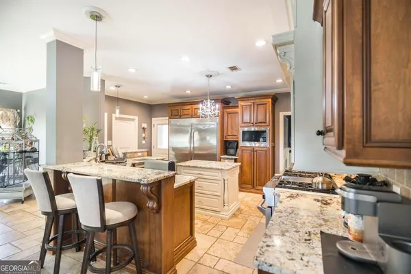 a dining hall with stainless steel appliances kitchen island granite countertop a dining table and chairs