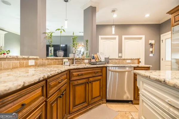 a large kitchen with granite countertop a sink and white cabinets