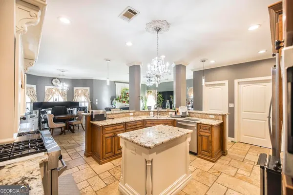 a kitchen with kitchen island a stove a sink a counter top space and living room view