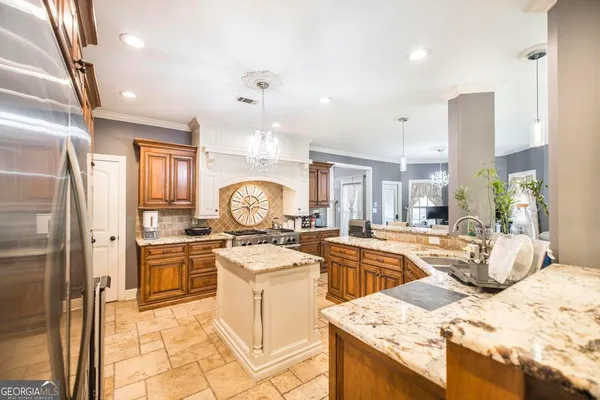 a kitchen that has a lot of white cabinets and stainless steel appliances