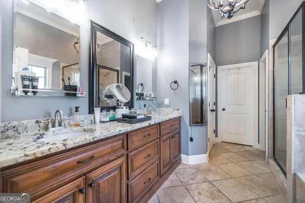 a spacious bathroom with a granite countertop sink a mirror and a shower