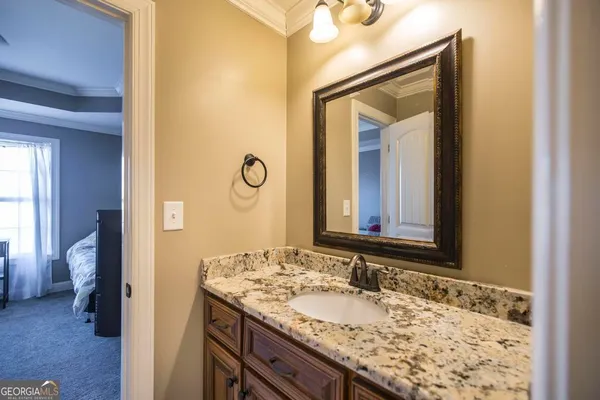 a bathroom with a granite countertop sink and a mirror