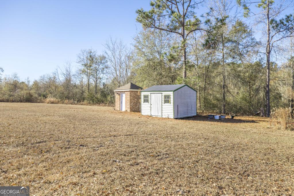 4065 Gordon Road Abbeville, GA 31001 - Photo 40 of 48 a backyard of a house with large trees and covered with wooden fence