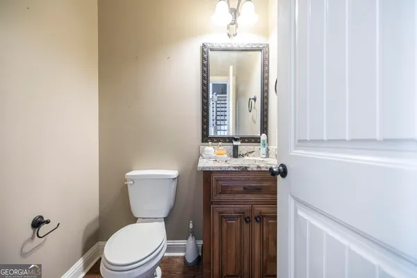a bathroom with a toilet a sink and mirror