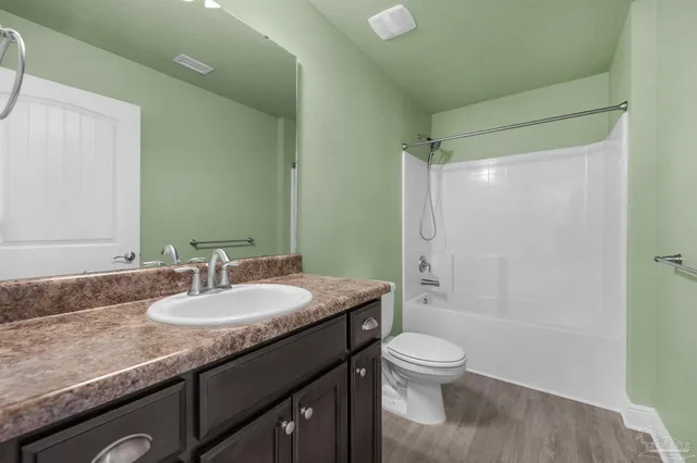 a bathroom with a granite countertop sink toilet a shower and a mirror