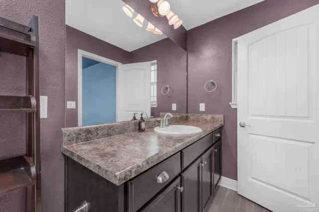 a bathroom with a granite countertop sink and a mirror