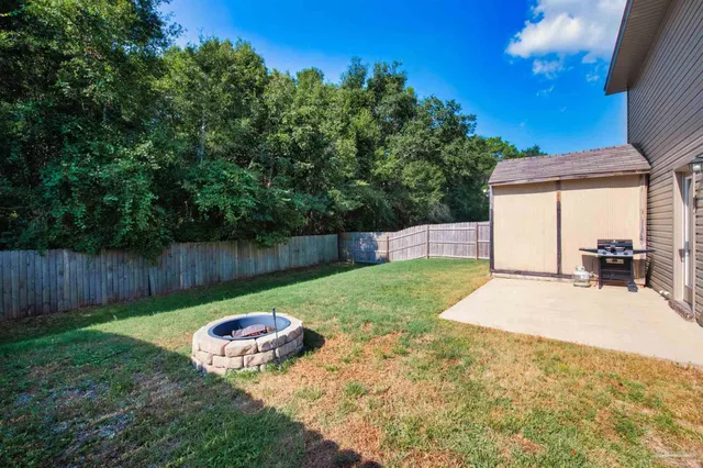 a view of a backyard with table and chairs and wooden fence