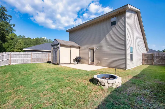 a backyard of a house with table and chairs