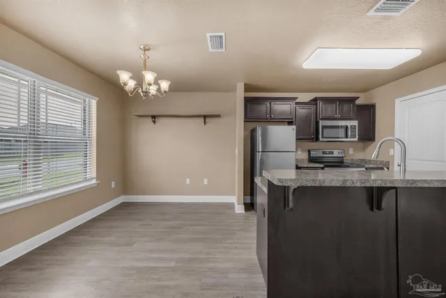 a view of a kitchen with a sink wooden cabinets and window
