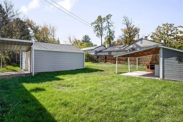 a view of a house with backyard and sitting area